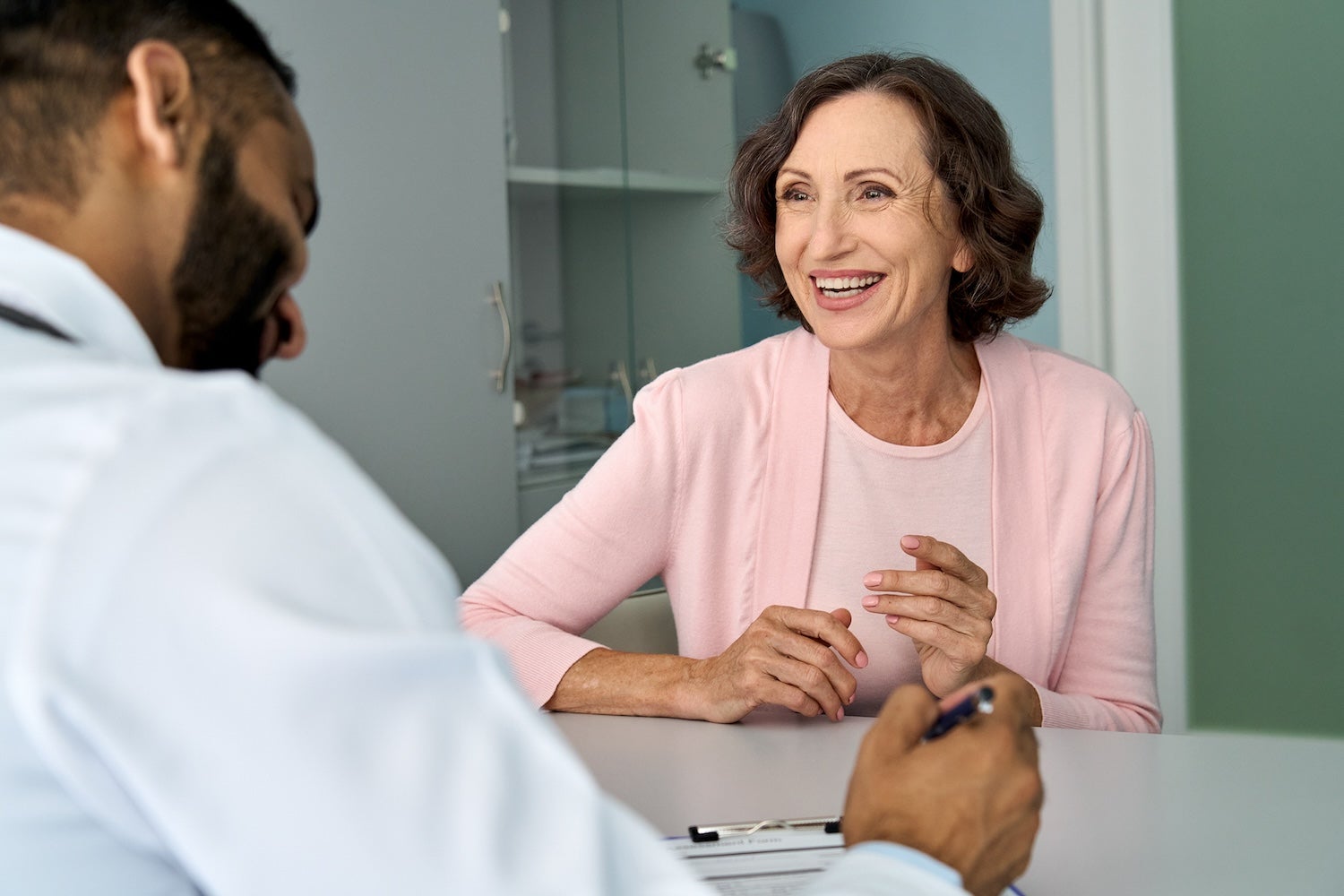 Doctor talking to happy smiling older lady